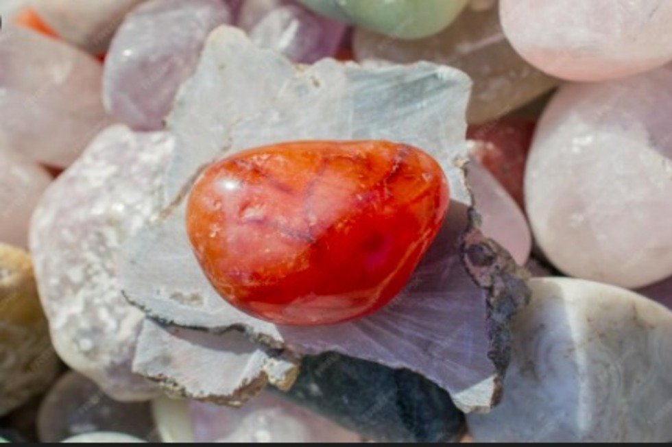 Cornalina pulida naranja sobre cristales, artículo sobre creatividad y motivación.